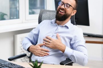 homme assis à son bureau qui a le sourire aux lèvres devant son ordinateur et respire le bien-être au travail en Nouvelle-calédonie
